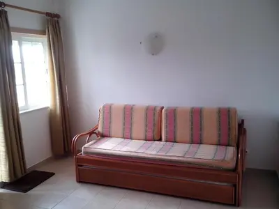 a couch sitting in a room with a window at Albufeira 1 bedroom apartment 5 min from Falesia beach and close to center D in Albufeira