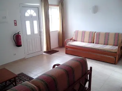a living room with a couch and a door at Albufeira 1 bedroom apartment 5 min from Falesia beach and close to center D in Albufeira