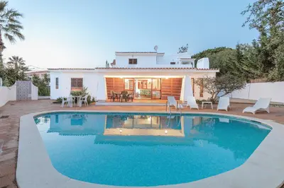 a villa with a swimming pool in front of a house at Casa das Anas by HelloVacations in Albufeira
