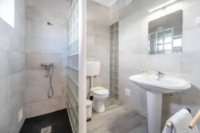 a white bathroom with a sink and a toilet at Casa das Anas by HelloVacations in Albufeira