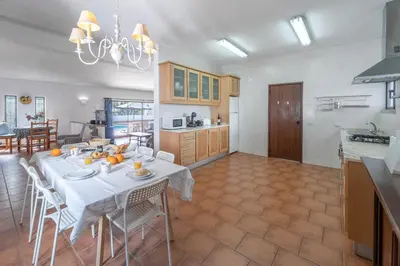 a kitchen and dining room with a table and chairs at Casa das Anas by HelloVacations in Albufeira