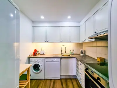a kitchen with white cabinets and a washing machine at FLH Vilamoura Sunny Apartment with Pool in Vilamoura