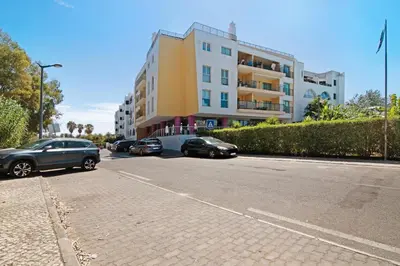 a street with cars parked in front of a building at PALM PARADISE SALGADOS in Albufeira