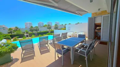 a patio with a table and chairs on a deck at Luxury villa & private heatable pool in Albufeira in Albufeira