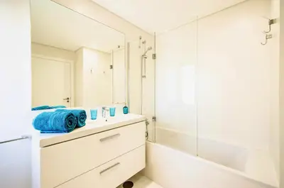 a bathroom with a sink and a tub and a mirror at Luxury villa & private heatable pool in Albufeira in Albufeira