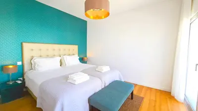 a bedroom with two beds and a blue wall at Luxury villa & private heatable pool in Albufeira in Albufeira