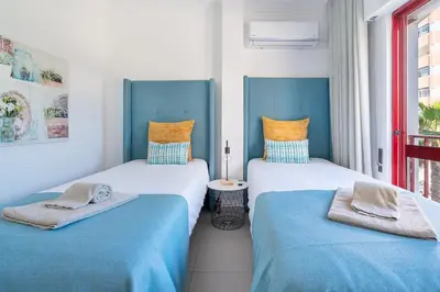 a bathroom with a toilet and a sink and a mirror at Apartamento Zacarias by Ferias com Sol in Quarteira