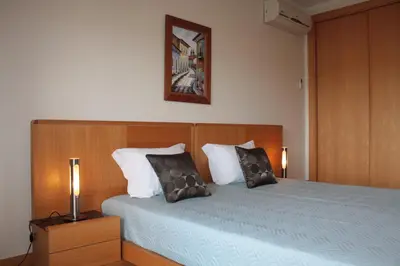 a bedroom with a bed with two pillows on it at Apartamento com Piscina em Albufeira, Corcovada in Albufeira