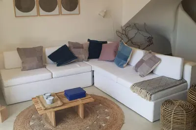 a living room with a white couch with pillows and a table at Old Village Design 3 Bedroom Townhouse in Vilamoura