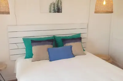 a white bed with blue and green pillows on it at Old Village Design 3 Bedroom Townhouse in Vilamoura