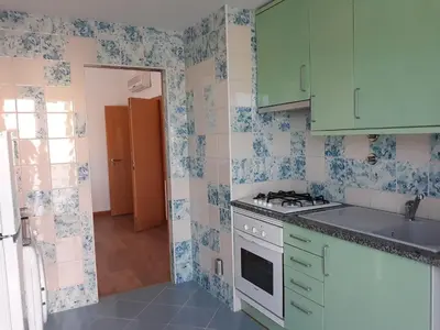 a kitchen with green cabinets and blue and white tiles at AMM SeaView Marina Albufeira apartment in Albufeira