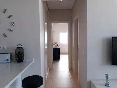 a white room with a hallway with a window at ABMAR- Por-do-sol, Vista mar, Remodelado, Wifi, 80mt Praia in Quarteira
