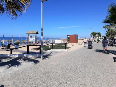people walking on a beach with the ocean in the background at ABMAR- Por-do-sol, Vista mar, Remodelado, Wifi, 80mt Praia in Quarteira