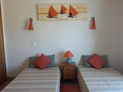 two beds in a room with red and blue pillows at AMM Albufeira Nice Hollydays apartment in Albufeira