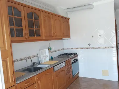 a kitchen with wooden cabinets and a sink at AMM Albufeira Nice Hollydays apartment in Albufeira