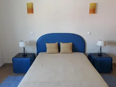 a blue bed with two lamps on two tables at AMM Albufeira Nice Hollydays apartment in Albufeira
