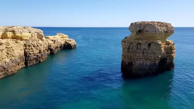 an island in the ocean with rocks in the water at Magnific Studio with a cozy garden, 5 minutes to the beach in Albufeira