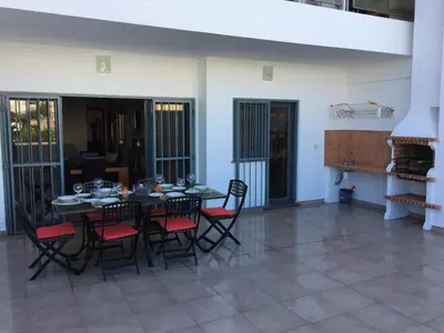 a dining room with a black table and chairs at Apt 2 Quartos, BBQ, AC, Terraço, Prestige For Home in Quarteira