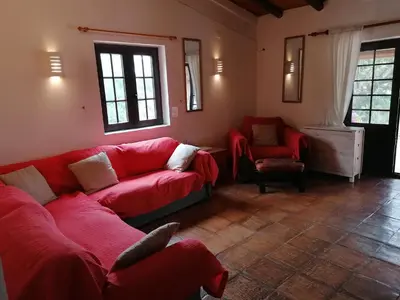 a living room with a red couch and a chair at La Quinta casa com piscina privada in Loulé