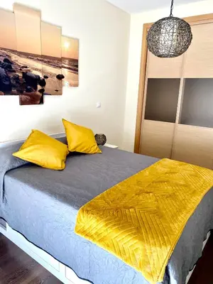 a bedroom with a bed with yellow pillows at Condomínio Olhos D'água T1 - Praia, sol e felicidade in Olhos de Água