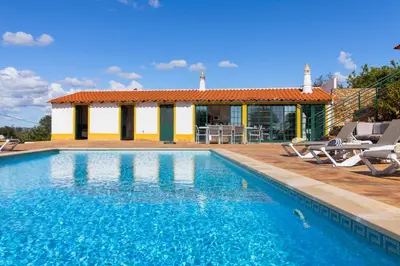 a swimming pool in front of a house at Villa Rita in Silves