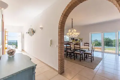 a dining room and living room with a table and chairs at Villa Rita in Silves