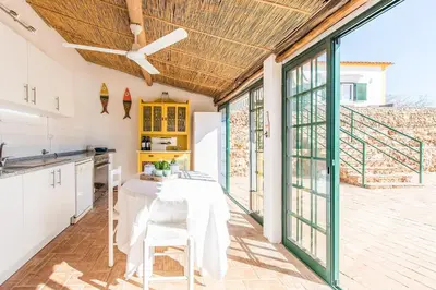 a kitchen with a table and some glass doors at Villa Rita in Silves