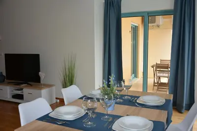 a dining room with a table with plates and wine glasses at Stunning Apartment with Marina Views in Albufeira
