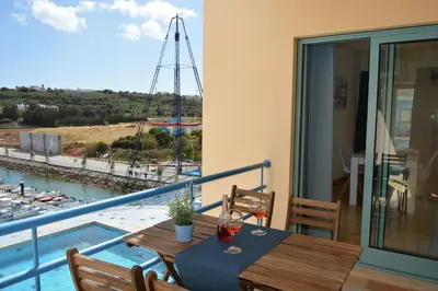 a balcony with a table with wine glasses on it at Stunning Apartment with Marina Views in Albufeira