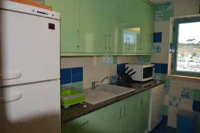 a kitchen with green cabinets and a sink at Stunning Apartment with Marina Views in Albufeira