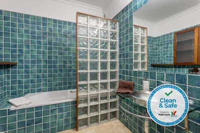 a blue tiled bathroom with a sign that says clean and sale at Moradia Ricardo - Praia da Gale in Albufeira