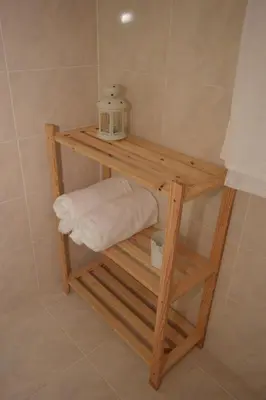 a wooden shelf in a bathroom with a towel at Irene's Place in Quarteira