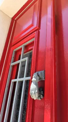 a red door with a stone animal sticking out of it at Casa da Mouraria in Faro