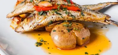 a plate of food with fish and potatoes at 241 Oliveiras Terraces in Albufeira