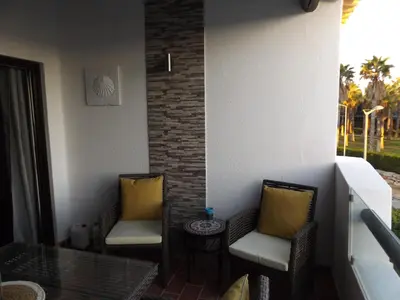 a balcony with two chairs and a glass table at Apartamentos Sao Rafael, 80b in Albufeira