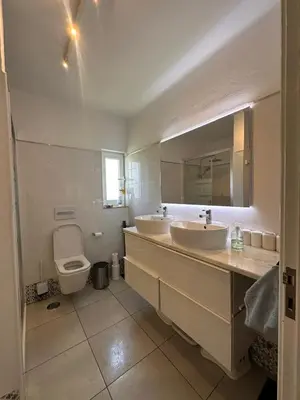 a bathroom with two sinks and a toilet at Apartamentos Sao Rafael, 80b in Albufeira