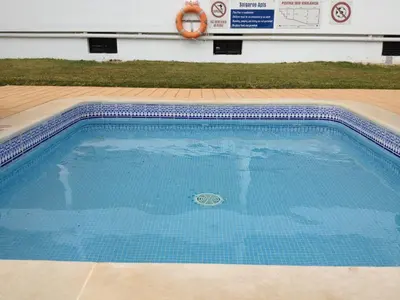 an empty swimming pool with a lifebuoy in a building at Solgarve in Quarteira