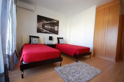 a bedroom with two beds with red covers and a rug at São Rafael Beach 300 m - Vila Rosal house in Albufeira