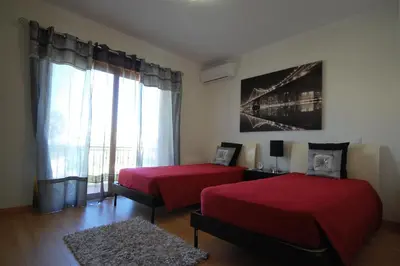 a bedroom with two beds and a large window at São Rafael Beach 300 m - Vila Rosal house in Albufeira