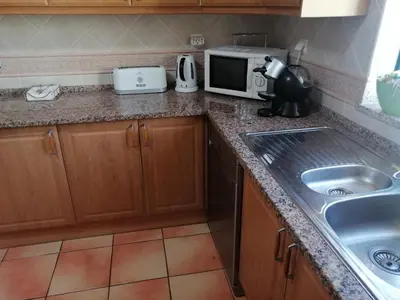 a kitchen with a table and chairs and a refrigerator at Beautiful Vila Rafaella, walk distance to beaches in Albufeira