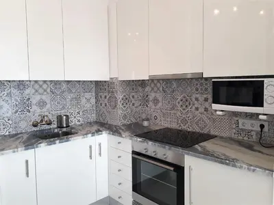 a white kitchen with white cabinets and a microwave at Atlantico 8- Vista Mar, Ar-Condicionado, 80mt Praia, Wifi in Quarteira