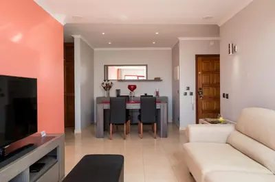 a living room with a table and a couch at Akisol Quarteira Gun in Quarteira