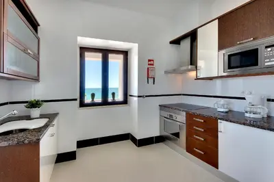 a kitchen with a sink and a microwave at Casa Pé na Areia- Unique Spot- Beach front by DreamvillasAlbufeira in Albufeira