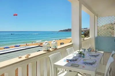a balcony with a table and a view of the beach at Casa Pé na Areia- Unique Spot- Beach front by DreamvillasAlbufeira in Albufeira
