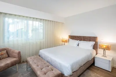 a bedroom with a large bed and a chair at Victory Village 3B in Quinta do Lago