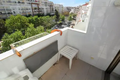 a white bench on a balcony with a view of a city at Comfortable studio in Albufeira - 20 m² - Pleasant balcony in Albufeira