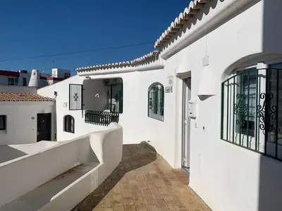 a white building with a walkway and a balcony at A CASINHA - Pateo Aldeia in Albufeira