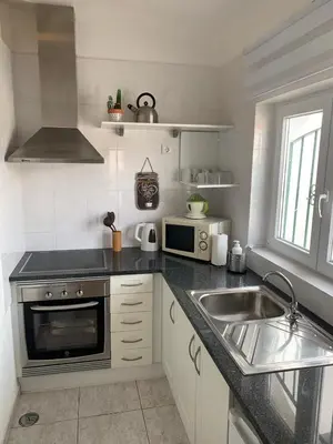 a kitchen with a sink and a microwave at A CASINHA - Pateo Aldeia in Albufeira
