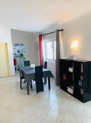 a dining room with a table and chairs and a kitchen at A CASINHA - Pateo Aldeia in Albufeira