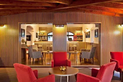 a lobby with red chairs and tables and a bar at Sao Rafael Holidays in Albufeira